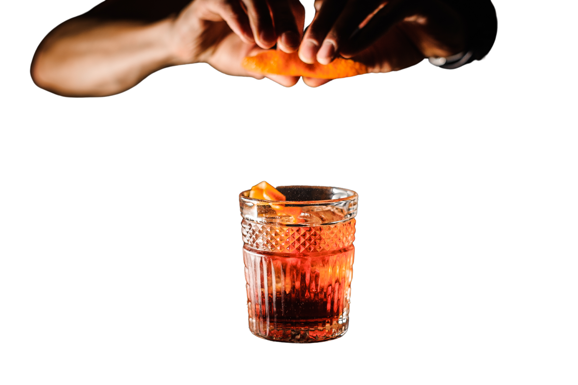 bartender with cocktail and orange peel preparing cocktail at bar